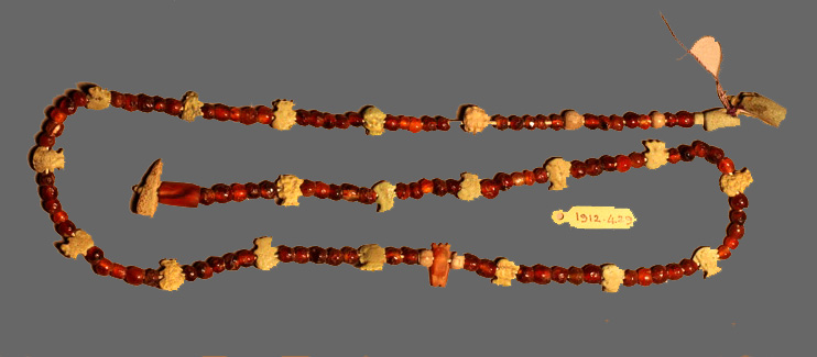 Carnelian ball beads separating amulets of faience Egyptian god Bes heads, crocodile, glaze beads