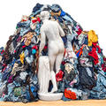 Installation showing a lifesize marble Venus statue with her back to us and walking into a big mound of colourful rags