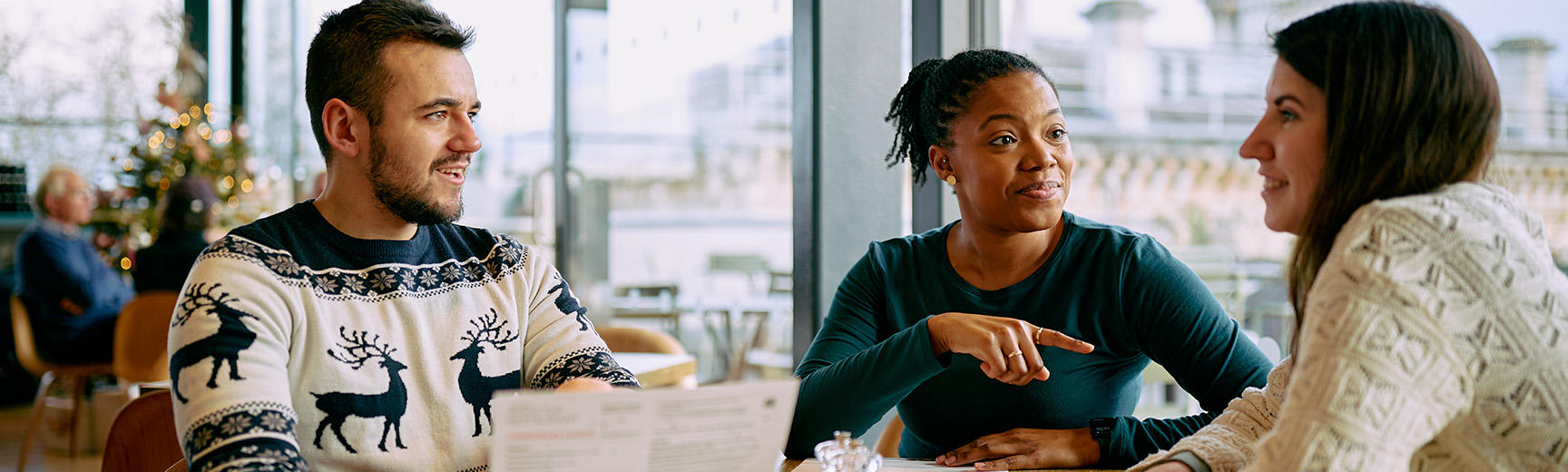 Group of visitors in the Rooftop Restaurant at Christmas time, the man on left wearing a Christmas jumper