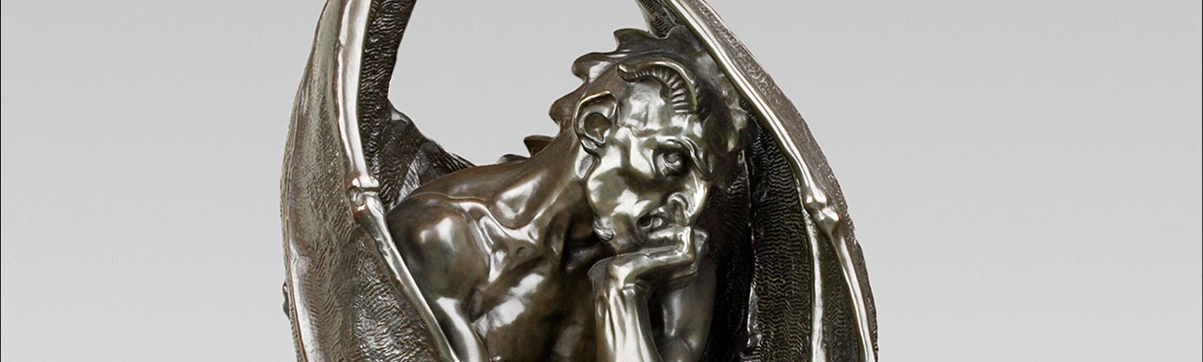 Satan sculpture detail showing the head and folded angel wings