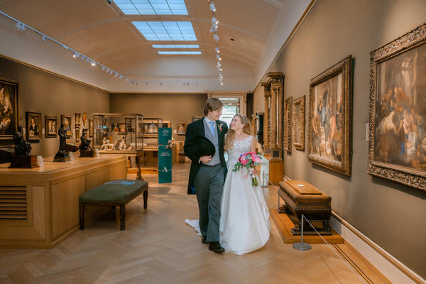 Portrait photo of bride and groom in european art gallery 