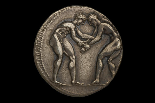 Ancient Greek silver coin depicting two wrestlers