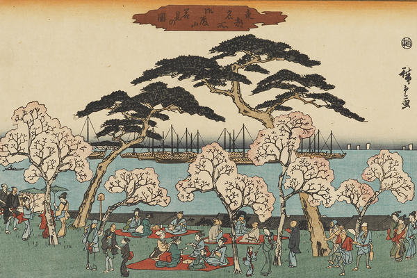 A woodblock print of a landscape featuring a group celebrating beneath cherry blossoms by the sea