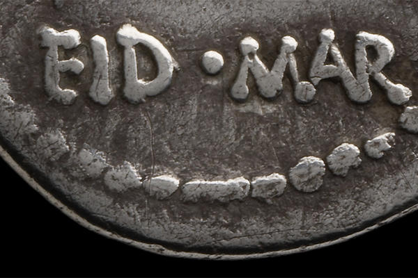 Bottom third of a silver coin with dotted edge detail and words EID MAR