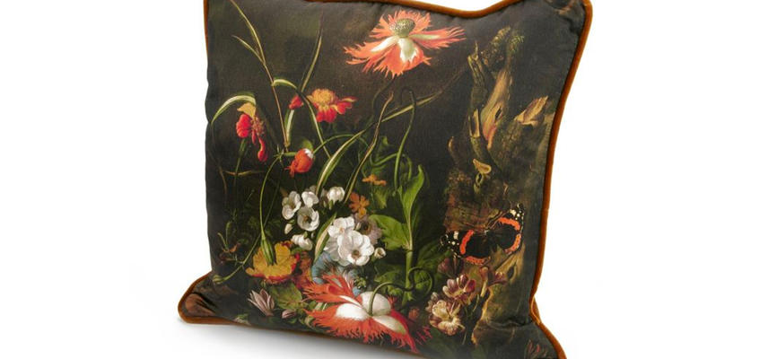 A photograph of a cushion decorated with a still life by Rachel Ruysch.