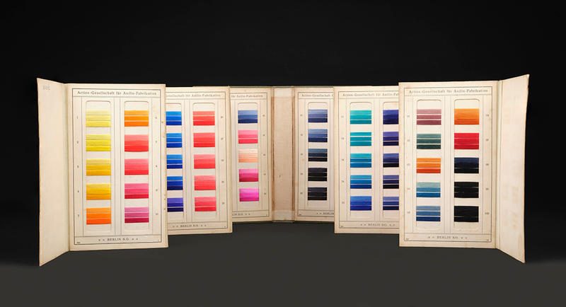 A folder of dyed samples ranging from yellow to pink, blue, green, brown and black by the Berlin aniline co.