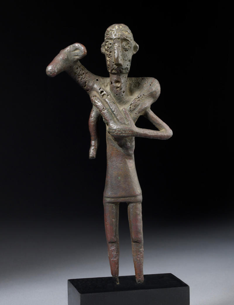 Bronze age figurine of a worshipper carrying a ram, 800-600 BCE, Copper alloy, 17.5 cm tall, AN1894.24 Bronze age figurine of a worshipper carrying a ram