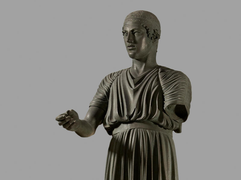 Painted plaster cast of an ancient Greek sculpture of a robed charioteer