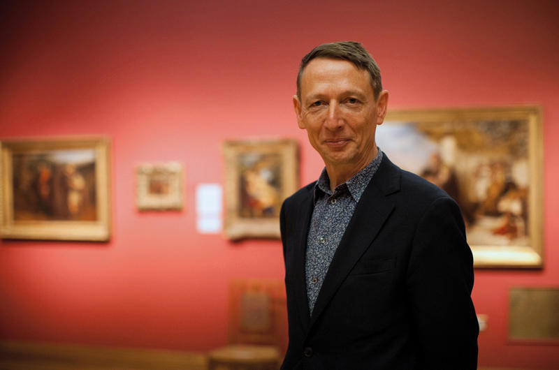Photograph of Dr Xa Sturgis, the Ashmolean Museum Director, who is stood in a gallery of paintings