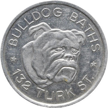 A silver token which shows the face of a bulldog. 'Bulldog Baths * 132 Turk St' is written around the image of the bulldog.