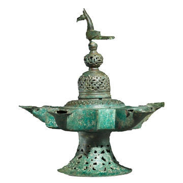 Oil lamp with dome shaped lid surmounted by a bird