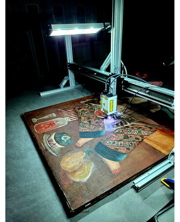 Examining the Setar player painting with conservation equipment 