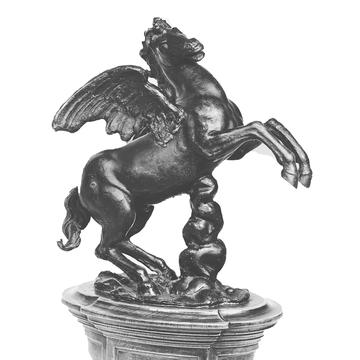 A black and white image of an metal sculpture of a winged horse (Pegasus) on its' hind legs