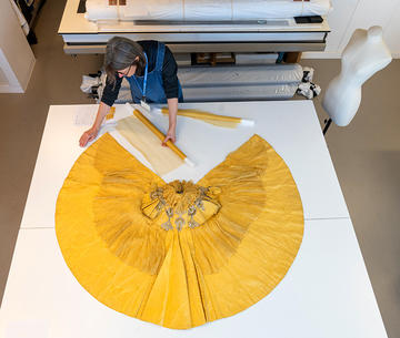 Yellow cape being treated in Conservation studio
